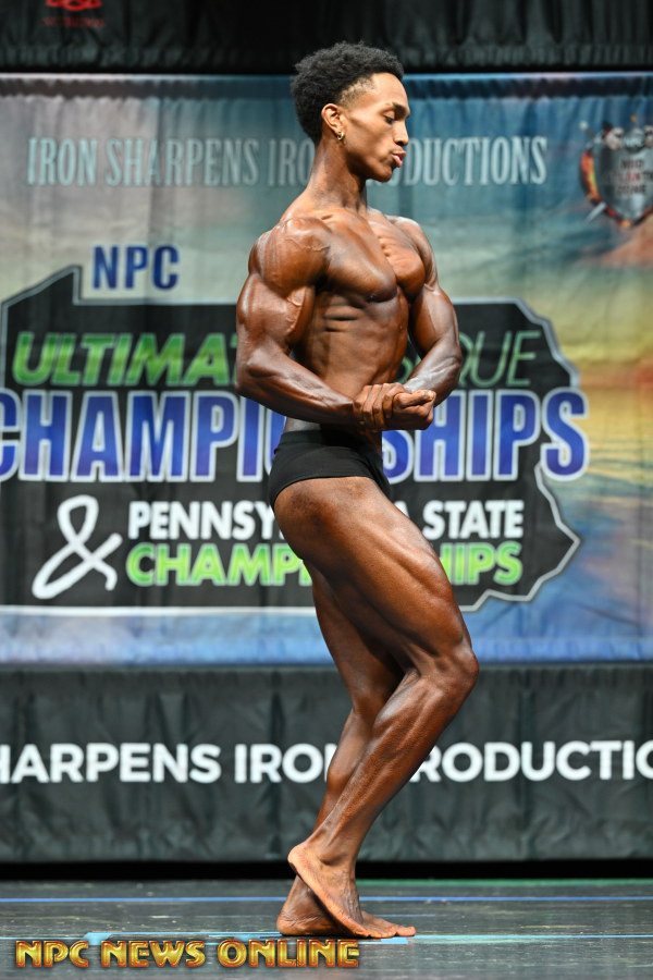 Team Red client hitting a side chest pose on the NPC stage